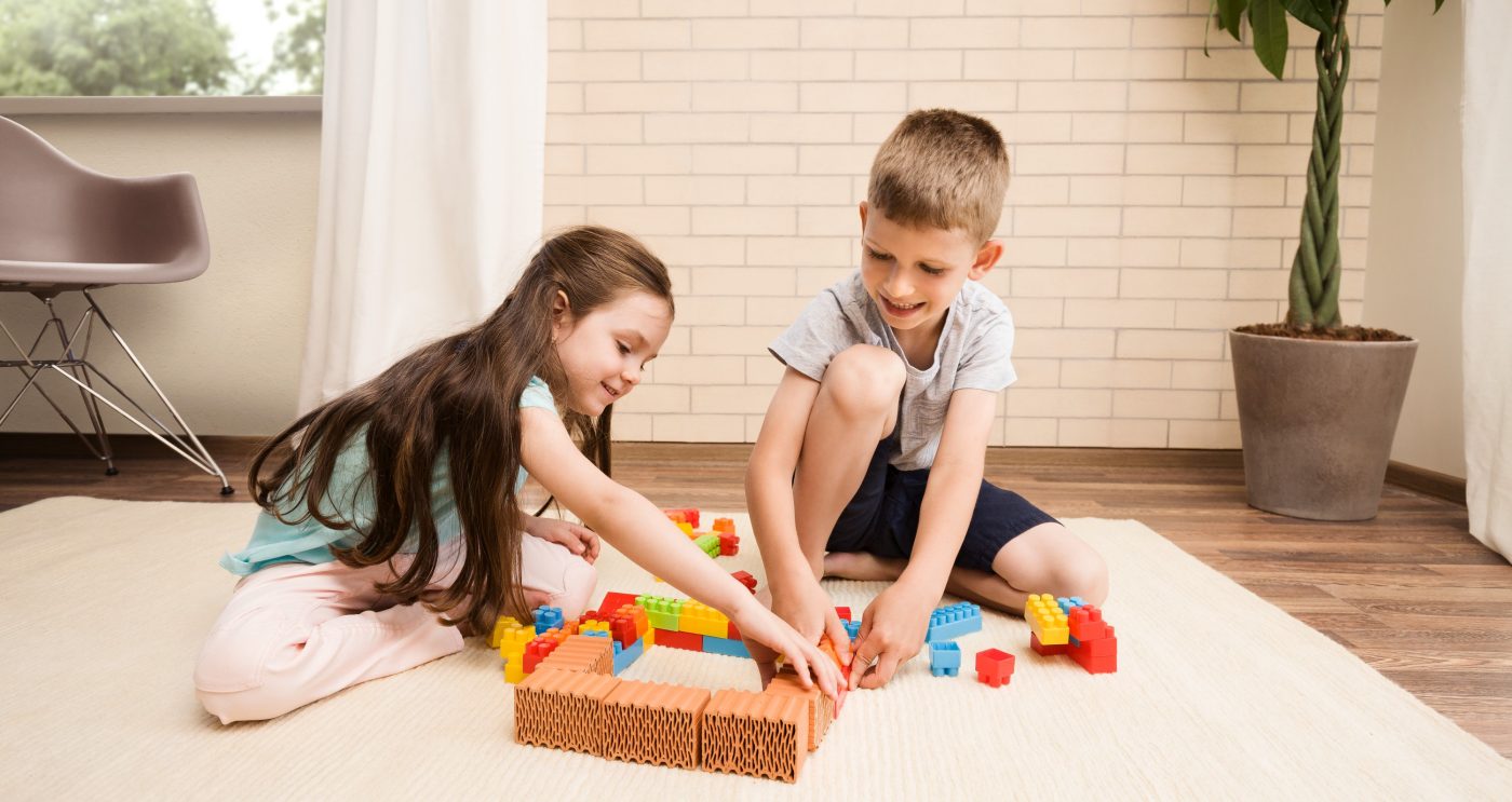 Children playing with miniature bricks and plastic building blocks