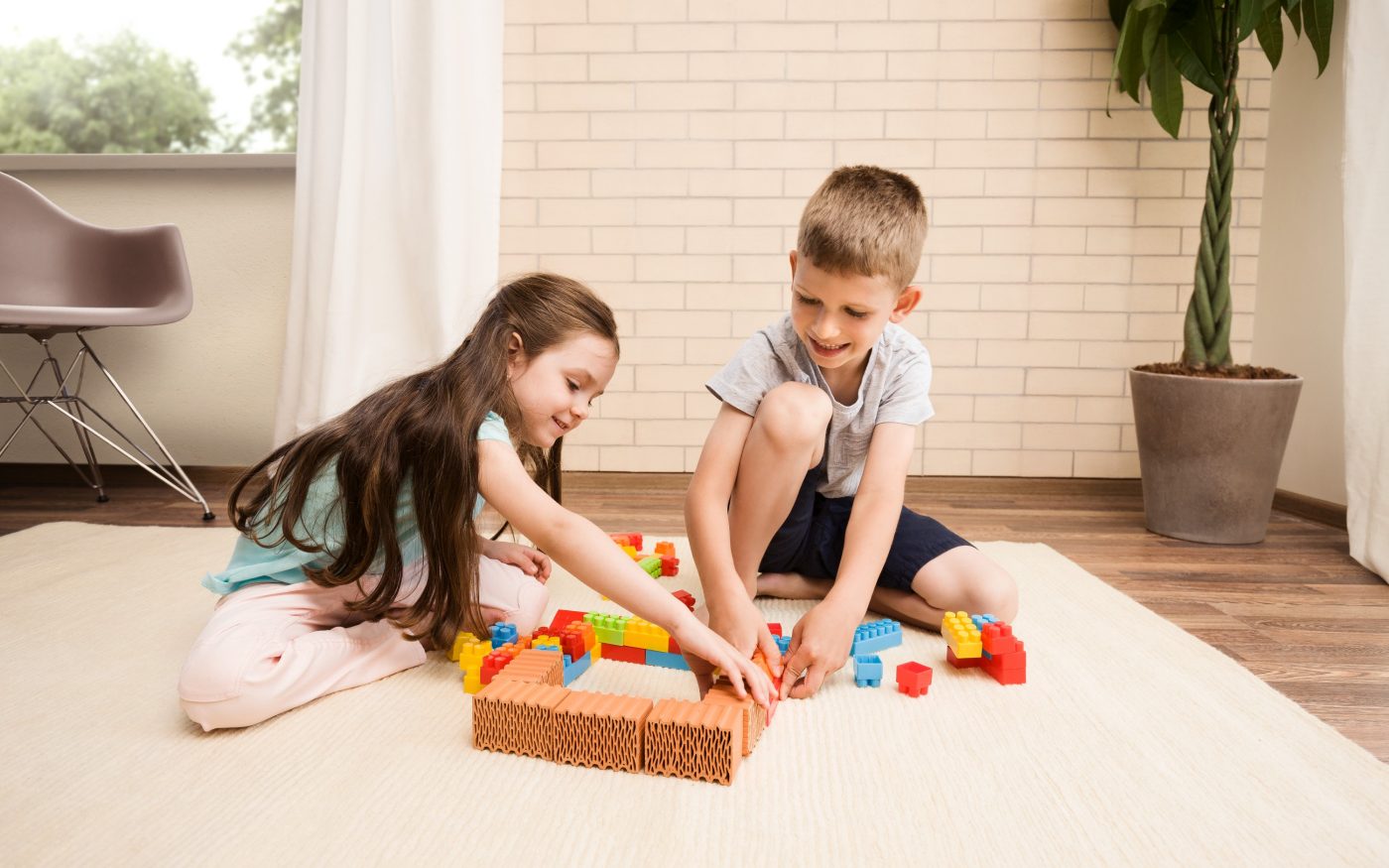 Children playing with miniature bricks and plastic building blocks