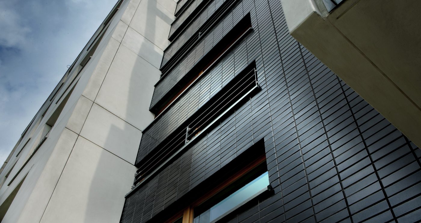 Multifamily setting with black glazed facing brick slips in Crakow